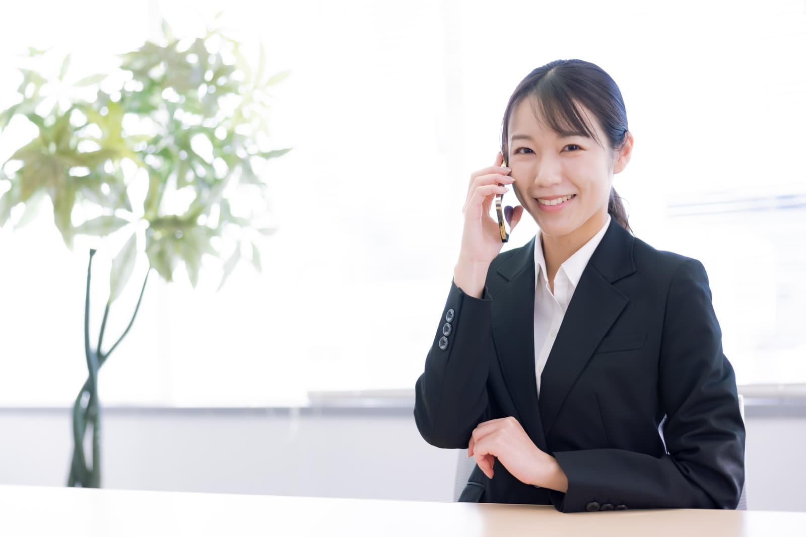 予約受付後の連絡対応を確認する日本人女性の写真